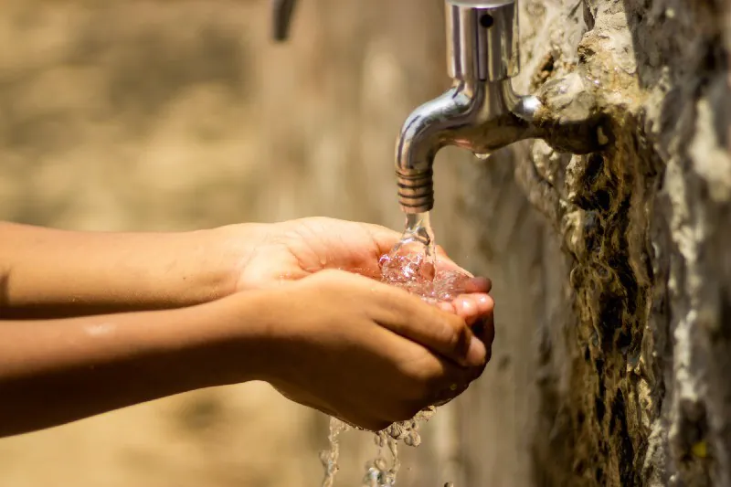 the boy takes the water in his hands